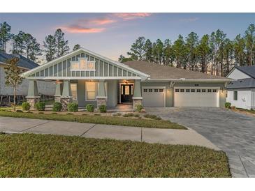 Charming single-story home with a three-car garage, covered entry, stone accents, and manicured lawn at 4801 Majestic Hills Loop, Brooksville, FL 34601