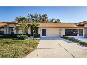 Brick house exterior with a two-car garage and well-manicured lawn at 9338 Clearmeadow Ln, New Port Richey, FL 34655