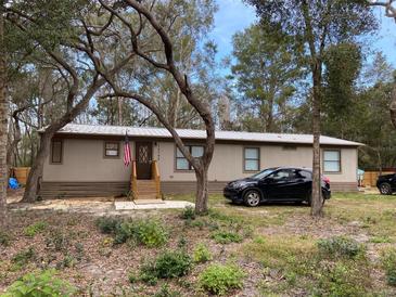 Single-wide manufactured home with a car parked in front and mature trees surrounding the property at 11743 Purdue St, New Port Richey, FL 34654