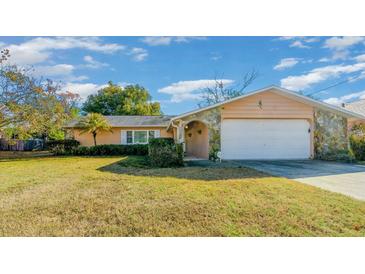 Single-story house with a peach-colored exterior, stone accents, and a spacious yard at 1318 Altoona Ave, Spring Hill, FL 34609
