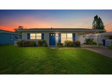 Charming single story home with a blue door and well-manicured lawn at 4424 Floramar Ter, New Port Richey, FL 34652