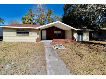 Tan single story home with brick entryway and walkway at 5641 Quist Dr, Port Richey, FL 34668