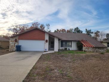 Ranch-style home with attached garage and mature landscaping at 10185 Horizon Dr, Spring Hill, FL 34608