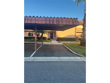 Covered parking carport with pathway to condo building entrance at 108 Lakeside Dr, Oldsmar, FL 34677