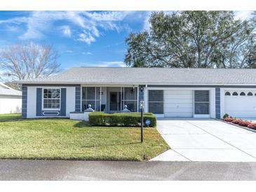 Front view of a single story home with a two car garage and screened porch at 11030 Linkside Dr # 11030, Port Richey, FL 34668