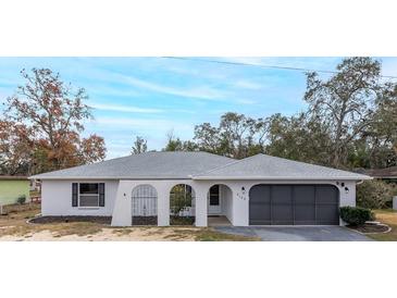 Newly renovated home with gray roof and modern garage doors at 6166 Newmark St, Spring Hill, FL 34606