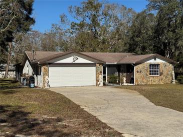 Ranch-style home with stone accents, attached garage, and mature landscaping at 9741 Star Trl, New Port Richey, FL 34654