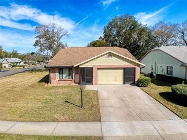 Brick ranch home with attached garage and well-manicured lawn at 11729 White Ash Dr, New Port Richey, FL 34654