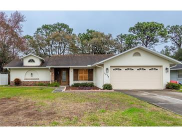 One-story home with attached garage, landscaped lawn, and neutral exterior at 1378 Haulover Ave, Spring Hill, FL 34608