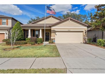 One-story house with a two-car garage and landscaped lawn at 15439 Stone House Dr, Brooksville, FL 34604