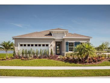 One-story home with a two-car garage and landscaped front yard at 2463 White Ladyfish Rd, Wimauma, FL 33598