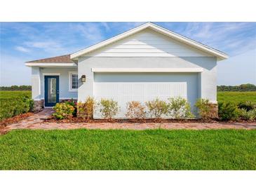 One-story home with light blue exterior, brick walkway, and a two-car garage at 2467 White Ladyfish Rd, Wimauma, FL 33598