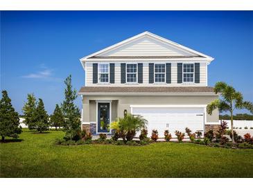 Two-story home with a neutral color palette, landscaped lawn, and two-car garage at 4502 Spire Run, Lakewood Ranch, FL 34211