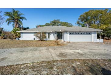 Single-story home with a two-car garage and landscaped yard at 5371 Joyner Ave, Spring Hill, FL 34608