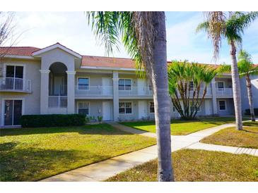 Exterior view of a two-story building with balconies and lush landscaping at 6801 Dali Ave # G104, Land O Lakes, FL 34637