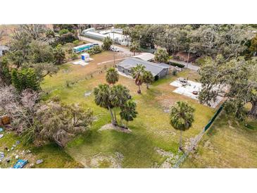 Expansive property featuring a single-Gathering home, lush greenery, and mature palm trees at 14034 Water Tower Dr, Hudson, FL 34667