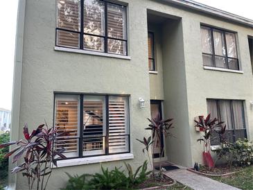 Light green two-story building with white shutters and landscaping at 1761 Cupecoy Cir # N-1, Lutz, FL 33558