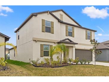 Two-story house with a large garage and manicured lawn at 194 Argyll Dr, Spring Hill, FL 34609