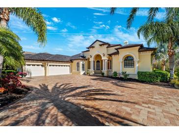 Grand home exterior with three-car garage and paver driveway at 20200 Lace Cascade Rd, Land O Lakes, FL 34637
