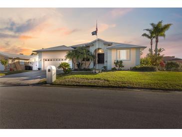 Single-story home with a two-car garage and landscaped lawn at 3912 Rudder Way, New Port Richey, FL 34652