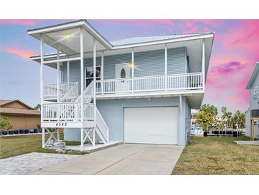 Inviting two-story coastal home featuring a spacious covered porch and convenient garage access at 4045 Centavo Ct, Hernando Beach, FL 34607