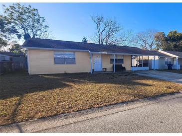 Yellow ranch home with porch and driveway at 4233 Mesa Dr, New Port Richey, FL 34653