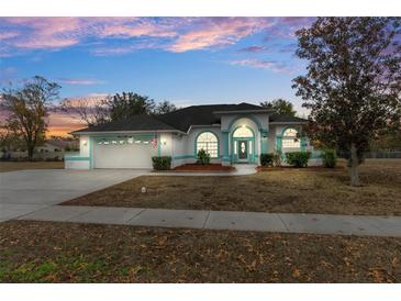 One-story house with attached garage, landscaping, and a teal accent at 4438 Crescent Rd, Spring Hill, FL 34606