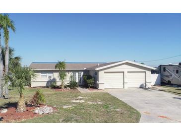 Single-story home with attached two-car garage and landscaped yard at 4949 Waterside Dr, Port Richey, FL 34668