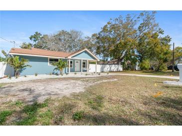 Charming blue single-Gathering home with a white rock lawn, young palms, and a welcoming front porch at 1310 Georgia Ave, Dunedin, FL 34698