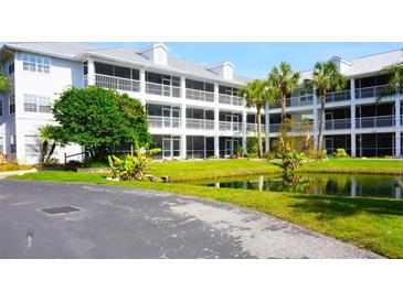 White two-story condo building with pond and landscaping at 2164 Vista Del Sol Cir # 505, Lutz, FL 33558