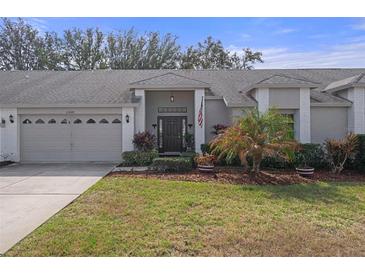 Charming single-story home boasts a well-manicured lawn, attached two-car garage, and inviting front entrance at 11008 Torrey Pines Ct, Hudson, FL 34667