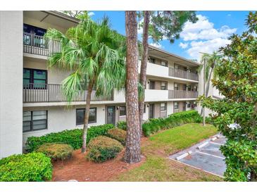 Condominium exterior with well-maintained landscaping and multiple stories of residences, and covered parking at 3038 Eastland Blvd # F103, Clearwater, FL 33761