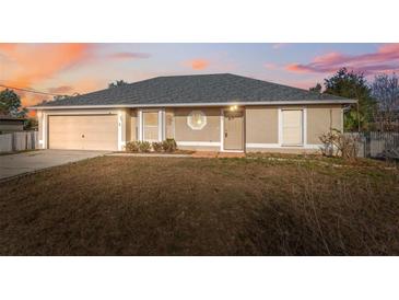 Tan single-story home with a garage, neutral trim, and well-maintained gray roof at 5155 Baldock Ave, Spring Hill, FL 34608