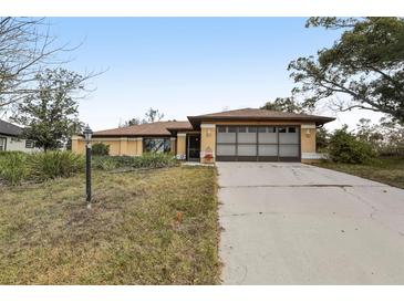 Inviting single-story home with a spacious driveway and an attached two-car garage at 1358 Newhope Rd, Spring Hill, FL 34606