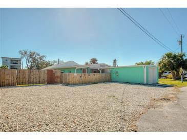 View of a one story home with a gravel yard and blue skies at 14824 Capri Ln, Hudson, FL 34667