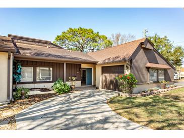 Charming single-story home with brown siding, a concrete driveway, and a well-manicured front yard at 2101 Sunset Point Rd # 2706, Clearwater, FL 33765