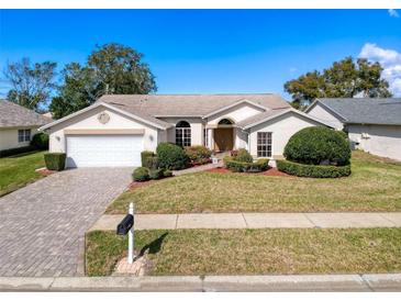 Charming single-story home features a manicured lawn, paved driveway, and attached two-car garage at 8447 Pavilion Dr, Hudson, FL 34667