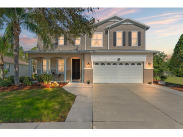 Charming two-story home featuring a well-maintained lawn, a two-car garage, and a welcoming front porch at 5412 Hammock View Ln, Apollo Beach, FL 33572