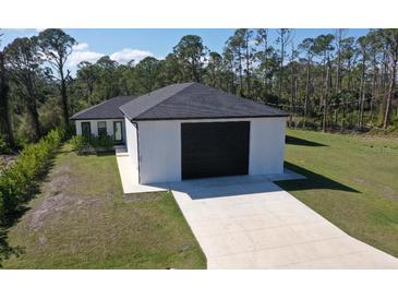 Newly constructed home with a spacious driveway and a large two-car garage at 435 Mcdill Dr, Port Charlotte, FL 33953