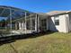 Screened in pool requiring maintenance surrounded by overgrown grass at 2781 Shady Ave, North Port, FL 34286