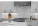 Stainless steel gas cooktop with designer backsplash and white shaker cabinets at 11826 River Shores Trl, Parrish, FL 34219