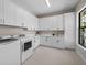 Spacious laundry room with white cabinets and a large window at 11826 River Shores Trl, Parrish, FL 34219