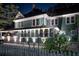 Charming two-story home featuring a cozy front porch, crisp white trim and manicured landscaping at night at 304 15Th W St, Bradenton, FL 34205
