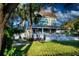 Two-story home with a covered porch, showcasing lush landscaping, and a tranquil outdoor seating area at 304 15Th W St, Bradenton, FL 34205