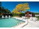 Community pool with lounge chairs and a yellow tree at 6016 Courtside Dr # 111, Bradenton, FL 34210