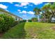 Spacious backyard with lush grass, palm trees, and waterfront views at 443 Picasso Dr, Nokomis, FL 34275