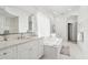 Bright bathroom boasts double sinks, a soaking tub, and stylish tile at 443 Picasso Dr, Nokomis, FL 34275