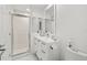 Clean bathroom with a walk-in shower, white vanity, and marble floor at 443 Picasso Dr, Nokomis, FL 34275