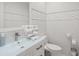 Modern bathroom with white leaf-patterned wall tiles and a glass vanity top at 443 Picasso Dr, Nokomis, FL 34275