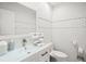 Stylish bathroom with white leaf-patterned wall tiles and a glass vanity top at 443 Picasso Dr, Nokomis, FL 34275